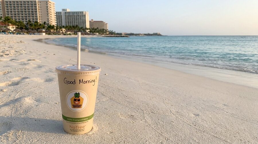 Palm Beach Aruba at sunrise with a fresh mango smoothie in the sand