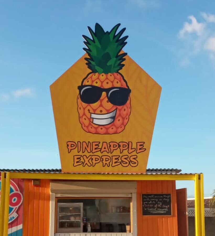 The Pineapple Express shop in Ponton, Aruba, with its full pineapple sign above the counter window